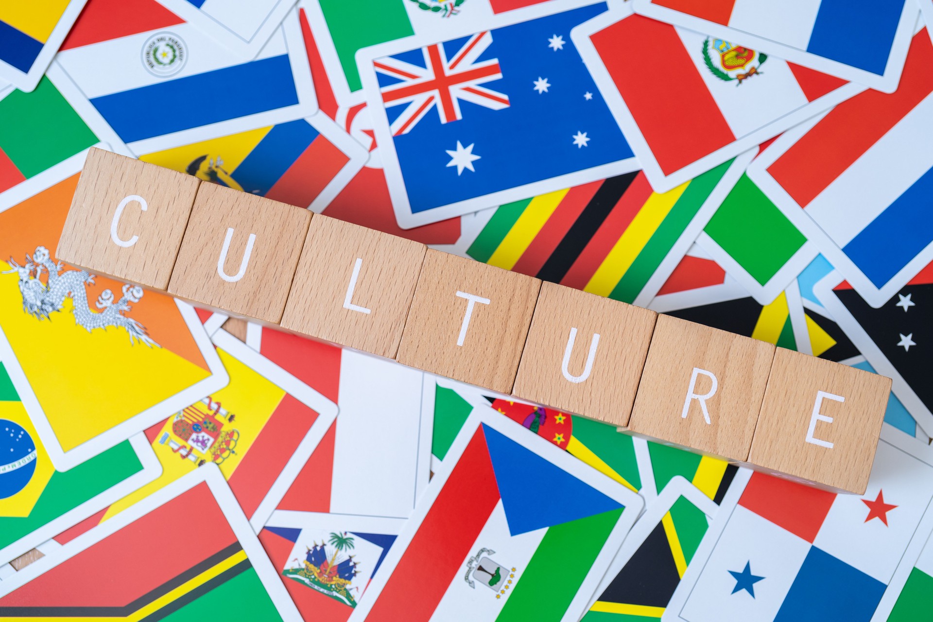Wooden blocks with "CULTURE" text of concept and many national flags.
